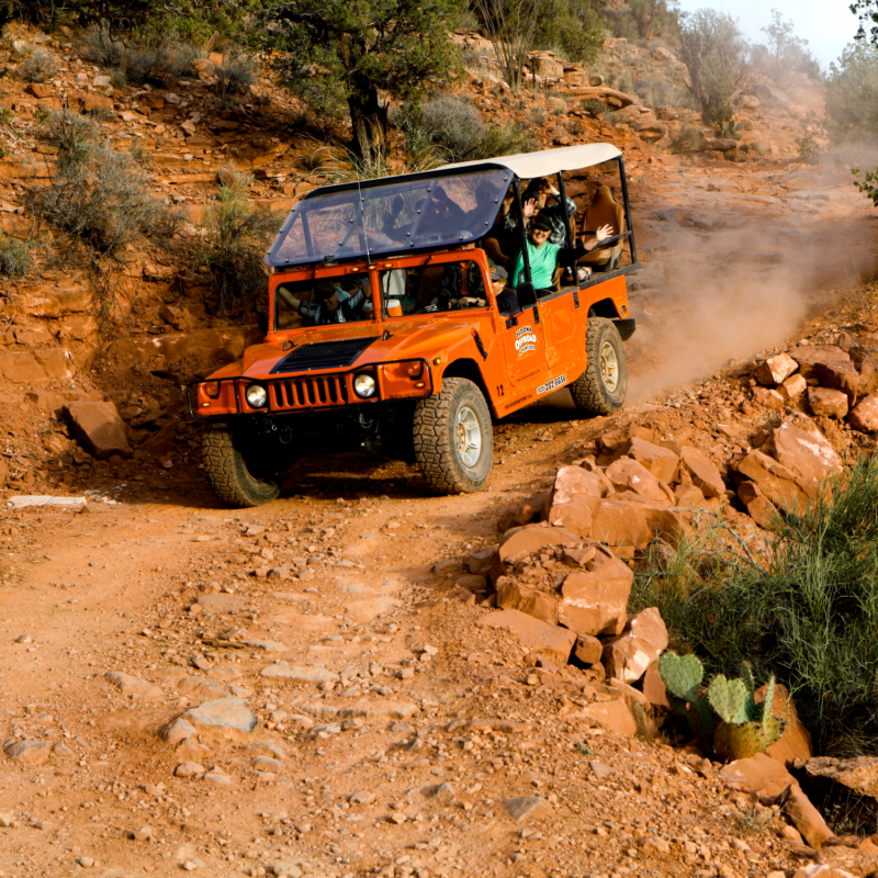 red jeep driving on rugged terrain