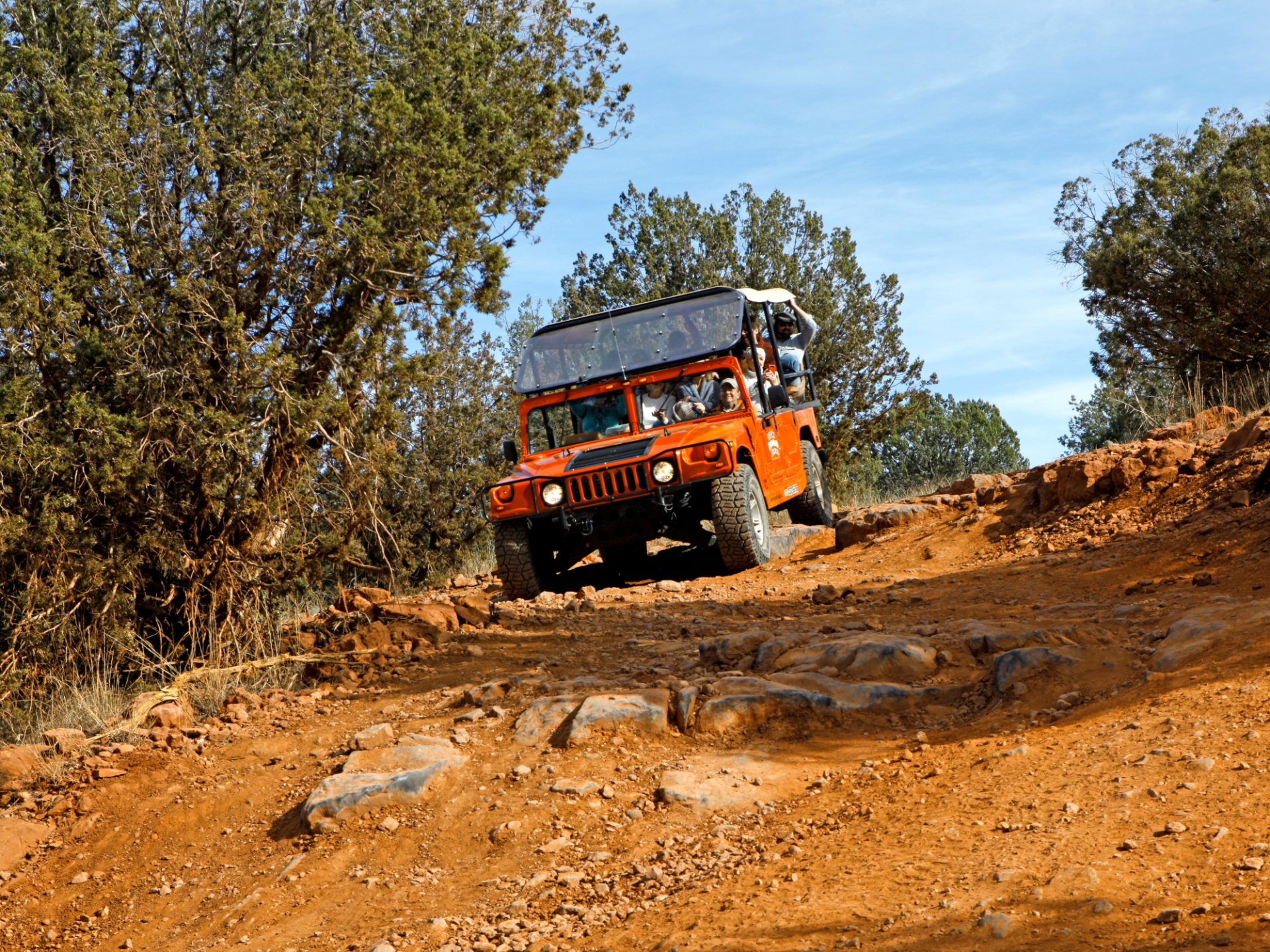 red jeep driving on rugged terrain