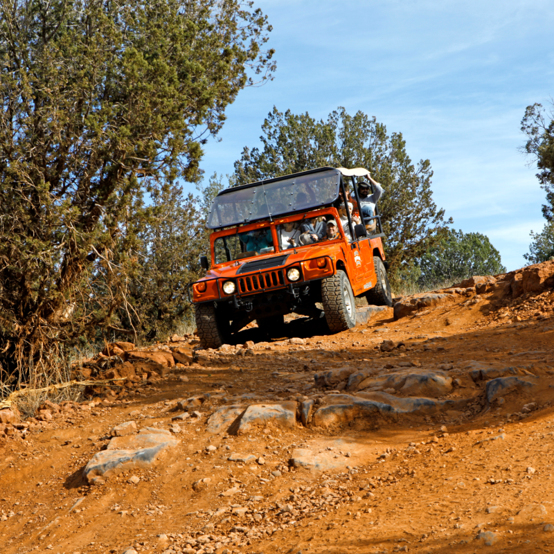 red jeep driving on rugged terrain