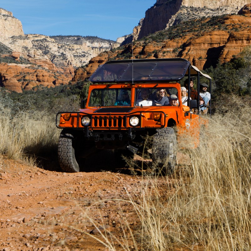 red jeep driving on rugged terrain